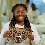 Woman holding a Grizzly mascot sign